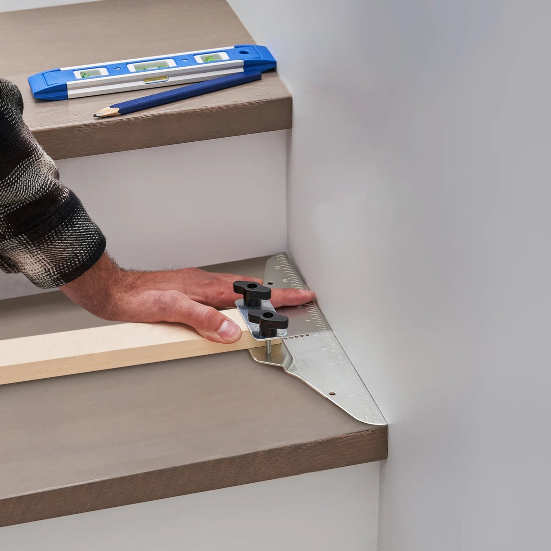 How to Use a Stair Tread Template Tool: Capturing precise corner angles with the Eleon metal stair gauge for professional flooring installation - Tool shown with wood tread, spirit level, and carpenter pencil.