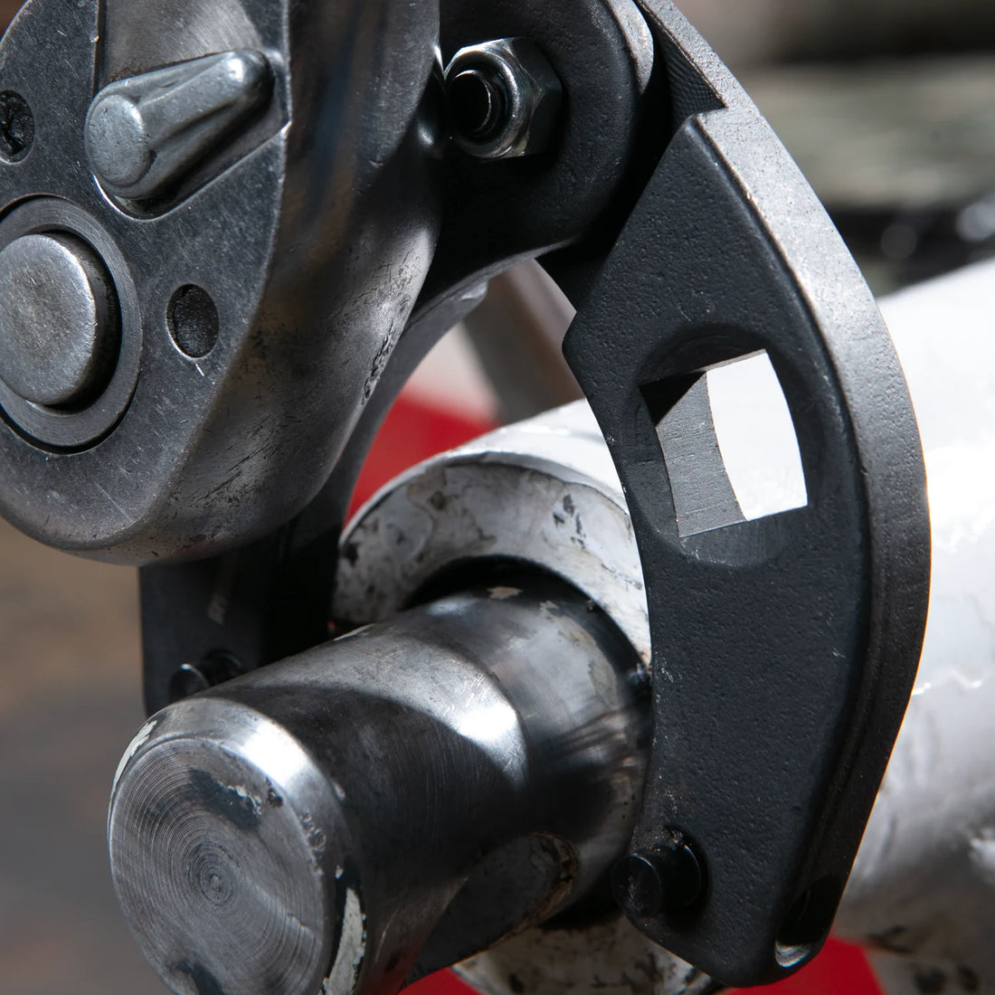 Rhino Gland Nut Wrench Macro View: Close-up of 1/2 inch square drive port engaged on a hydraulic cylinder gland nut - High-strength carbon steel tool for excavator and backhoe repair.